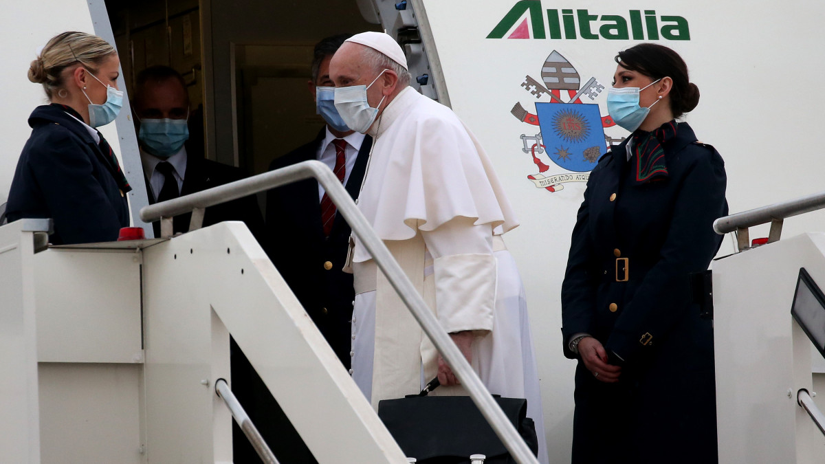 ROME, ITALY - MARCH 05:  Pope Francis greets  an Alitalia hostess as he departs for his  trip to Iraq from Leonardo Da Vinci airport  on March 05, 2021 in Rome, Italy. Pope Francis will start the historic first ever papal visit to Iraq. In his first foreign trip since the start of the pandemic Pope Francis will visit Baghdad, Najaf, Erbil and the cities of Qaraqosh and Mosul, which were heavily destroyed by ISIS. Although the trip is seen as an act of solidarity, the Vatican has been forced to defend the decision to go ahead with the papal visit amid the ongoing coronavirus pandemic, as Iraq is currently seeing a spike in infection rates as it faces a deadly second wave of the virus. (Photo by Franco Origlia/Getty Images)