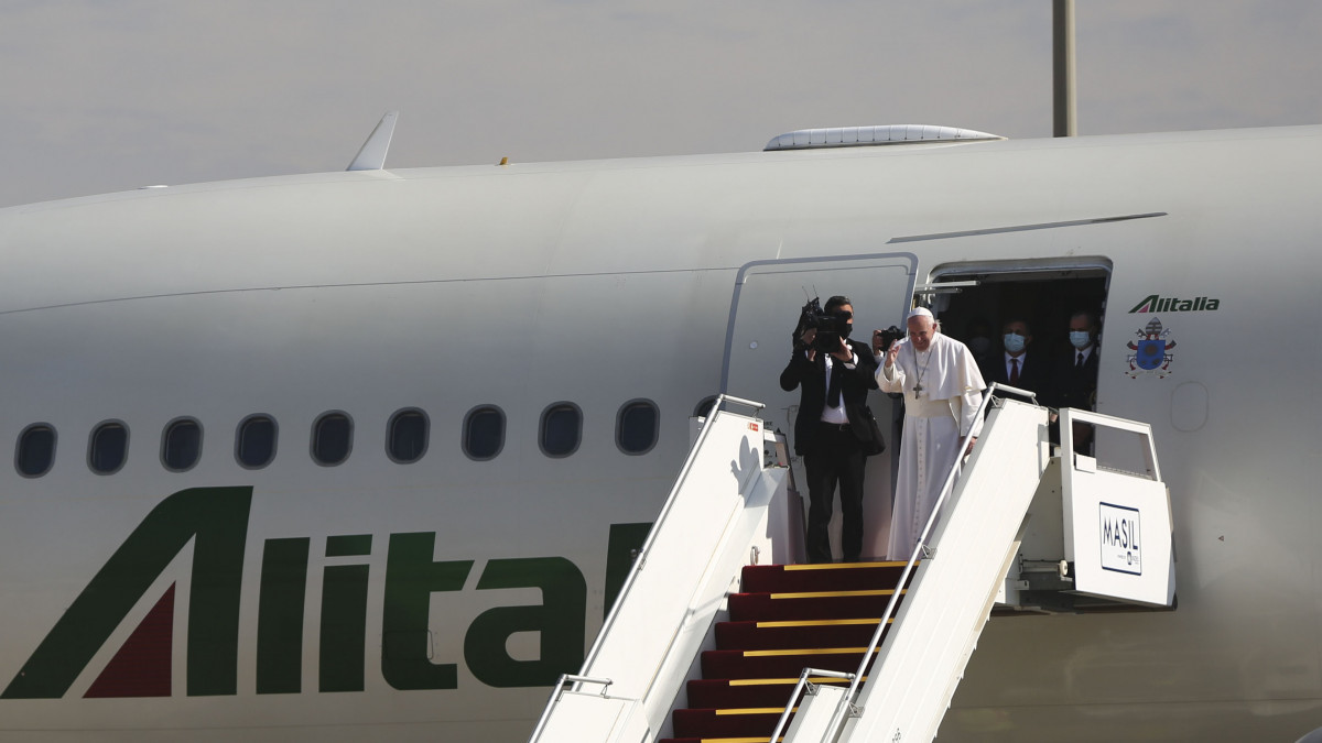 BAGHDAD, IRAQ - MARCH 08: Pope Francis waves to the Iraqi president Barham Salih before boarding his Alitalia Airbus A330 aircraft at Baghdad International Airport as he concludes a four days historical trip around Iraq on March 8, 2021 in Baghdad, Iraq. Pope Francis departed Iraq after his historic visit, the first papal visit to the country. In his first foreign trip since the start of the pandemic Pope Francis visited Baghdad, Najaf, and the cities of Qaraqosh and Mosul, which were heavily destroyed by ISIS. He concluded his trip with a large mass in Erbil. (Photo by Taha Hussein Ali/Getty Images)