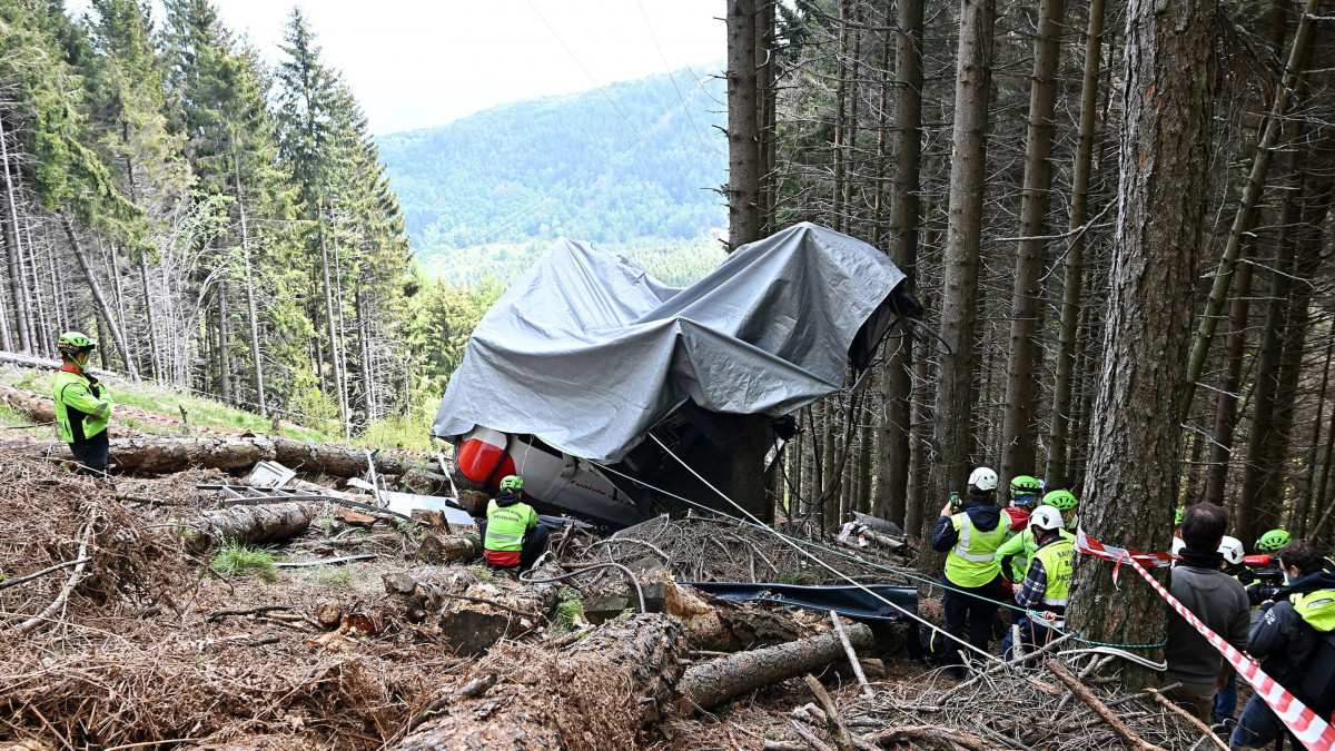Mentőalakulatok tagjai vizsgálják a Stresa települése és a Mottarone-hegy között közlekedő függővasút egyik lezuhant fülkéjét Verbania közelében 2021. május 26-án. A három napja történt balesetben legkevesebb 14 ember életét vesztette, egy gyerek súlyosan megsebesült.