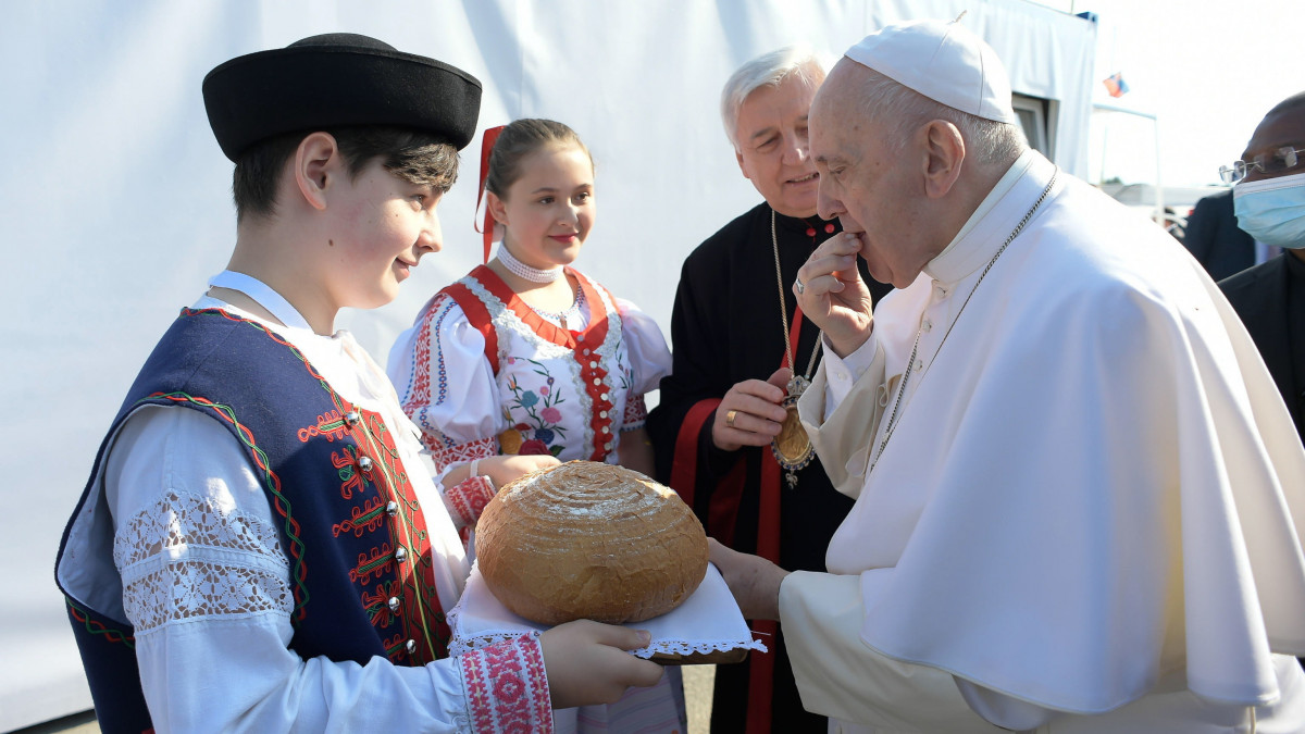 Népviseletbe öltözött fiú kenyérrel köszönti Ferenc pápát a városi sportcsarnok előtti téren Eperjesen 2021. szeptember 14-én. A katolikus egyházfő négynapos látogatáson tartózkodik Szlovákiában.