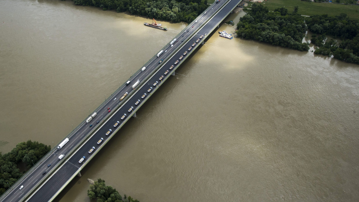 Teherautók az M0 autópálya déli szektorának bővítéséhez épült új, 770 méter hosszú hárosi Duna-hídon 2013. június 4-én. Amennyiben a próbaterhelés során mért adatok egyeznek a számítottakkal, akkor az M6 autópálya és az 51-es számú főút közötti 11 kilométer hosszú szakaszon legkésőbb július végén megindulhat a forgalom.