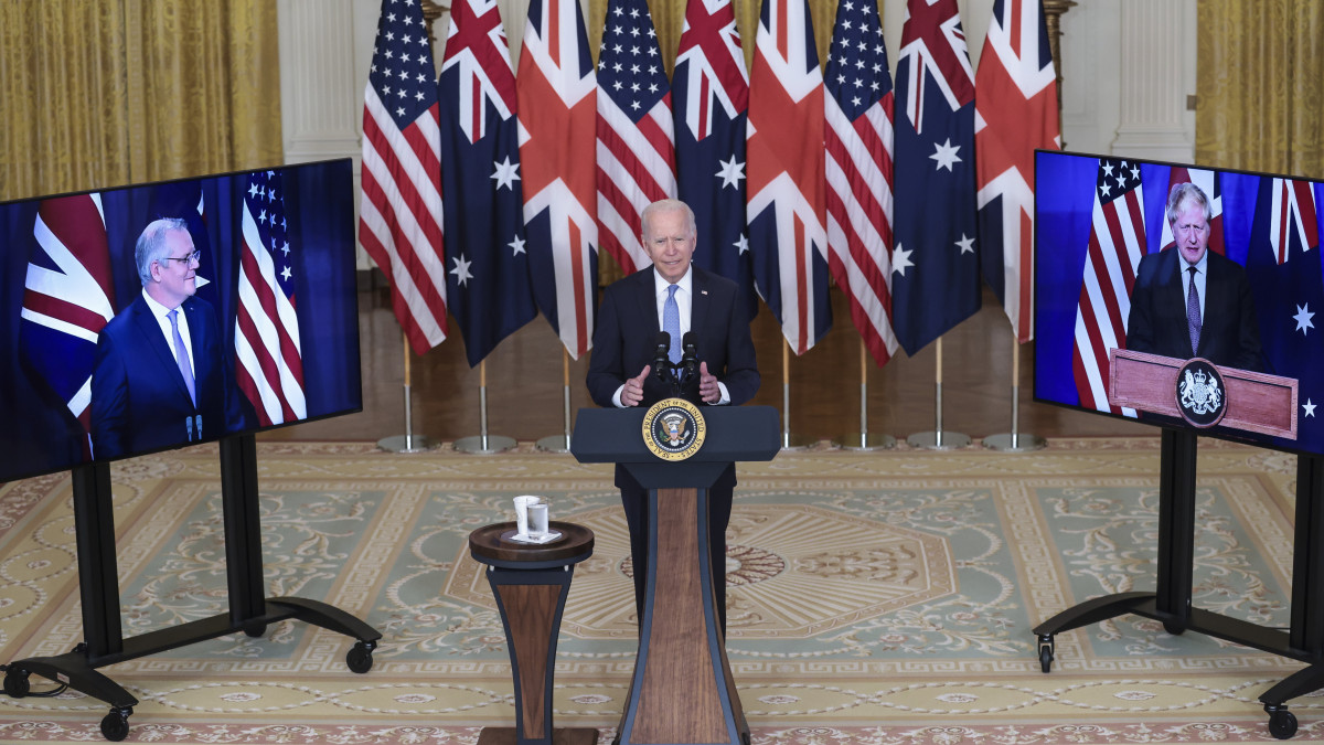 Joe Biden amerikai elnök (k), Scott Morrison ausztrál miniszterelnök (b) és brit hivatali partnere, Boris Johnson (j) videokonferencia keretében tart sajtótájékoztatót a washingtoni Fehér Házban 2021. szeptember 15-én. A sajtóértekezleten bejelentették, hogy háromoldalú védelmi és biztonsági partnerséget hoztak létre. A három ország angol nevének rövidítésből AUKUS-nak elnevezett kezdeményezés elsődleges céljai közé tartozik az ausztrál haditengerészet felszerelése nukleáris meghajtású, de hagyományos fegyverzettel ellátott tengeralattjárókkal, az indiai- és a csendes-óceáni térség stabilitásának fenntartása érdekében.