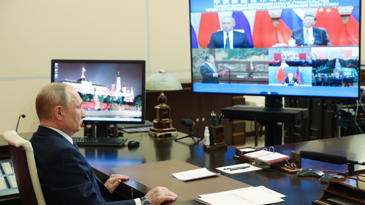 Vlagyimir Putyin orosz elnök és kínai hivatali partnere, Hszi Csin-ping (a kijelzőn fent, j) részt vesz a kínai Xudabao és Tianwan atomerőművek új blokkjai építésének megkezdése alkalmából rendezett, videokonferencia keretében tartott ünnepségen a Moszkva melletti Novo-Ogarjovóban lévő elnöki rezidencián 2021. május 19-én.
