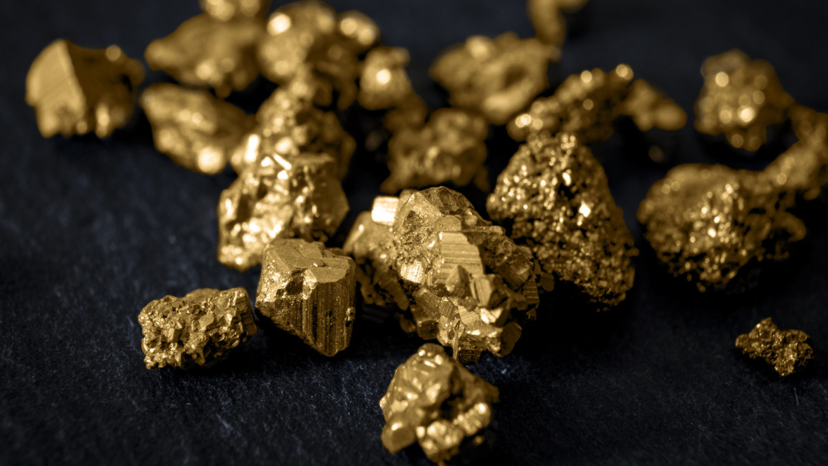 Gold mining and and investment in precious metals concept with close up on golden nuggets on a black background