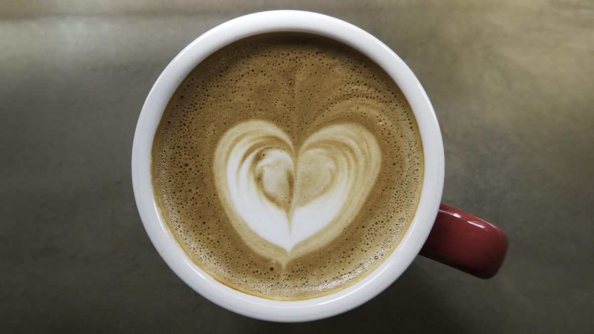 Cafe latte foam in red cup close up