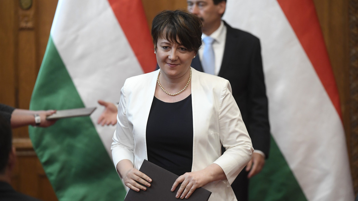 Juhász Edit, a Miniszterelnöki Kormányiroda államtitkára, miután átvette a kinevezési okmányt Áder János köztársasági elnöktől (hátul) az Országház Vadásztermében 2018. május 22-én.