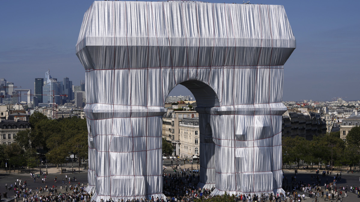 A néhai Christo bolgár származású csomagolóművész és felesége, alkotótársa, Jeanne-Claude tervei alapján becsomagolt párizsi diadalív 2021. szeptember 18-án. Az installációt 25 ezer négyzetméternyi újrahasznosított ezüstös kék műanyaggal és 3000 méter vörös kötéllel hozták létre.
