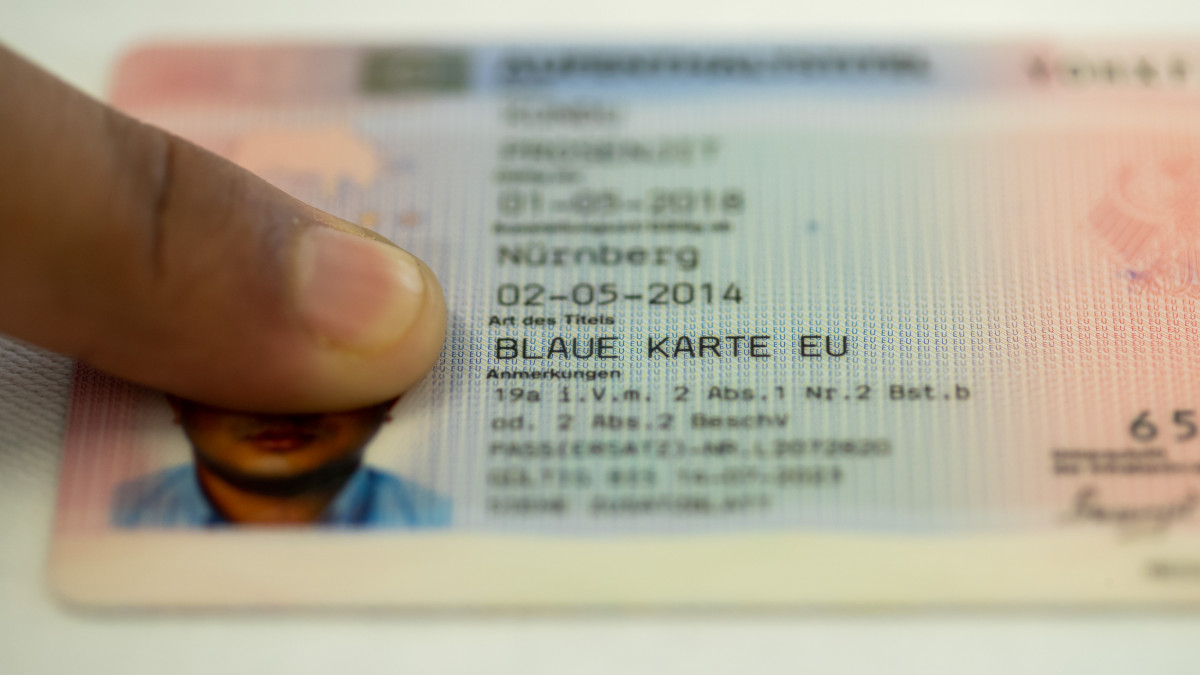 5 July 2018, Nuremberg, Germany: A Blue CardÂ for foreign workers can be seen at the Federal Office for Migration and Refugees (BAMF) on a table. Some 77000 highly qualified migrants from non-EU countries have acquired the so-called Blue Card to work in Germany. A large portion of these people work in-demand jobs as engineers, scientists, programmers or doctors. Photo: Daniel Karmann/dpa (Photo by Daniel Karmann/picture alliance via Getty Images)