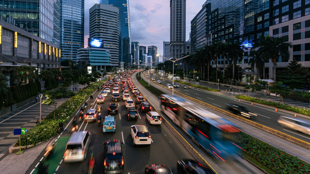 Traffic, captured with blurred motion, rush along the main avenue lined with skyscrapers in the business district in Indonesia capital city.