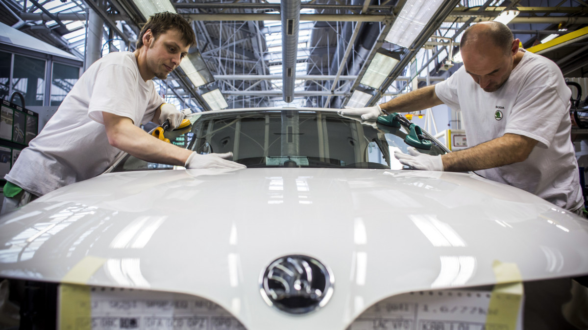 Workers attach windscreen glass to a Skoda automobile on the production line at Volkswagen AGs Skoda Auto AS manufacturing plant in Mlada Boleslav, Czech Republic, on Friday, March 27, 2015. The Czech Republic will benefit from adopting the euro and should join the monetary union after the Greek debt crisis calms down, the head of Volkswagen AGs unit, Skoda Auto AS, said. Photographer: Martin Divisek/Bloomberg via Getty Images