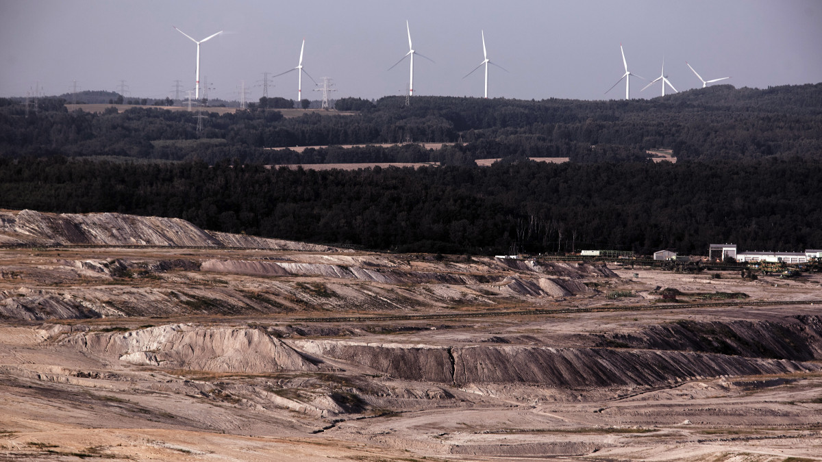 Wind turbines operate beside the excavated terrain of the Turow coal mine, operated by PGE SA, in Bogatynia, Poland, on Sunday, Aug. 15, 2021. European companies chasing zero-emission targets are starting to turn to countries such as Poland to bolster theirÂ clean-power supplies. Photographer: Bartek Sadowski/Bloomberg via Getty Images