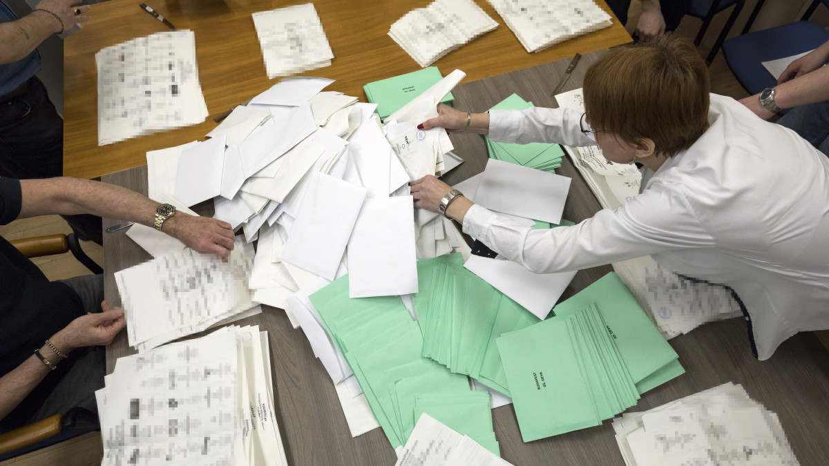 Az átjelentkezéssel szavazók, illetve a külképviseleten szavazók borítékjait bekeverik a választás estéjén fel nem bontott urnákba, és így számlálja meg a voksokat a szavazatszámláló bizottság a főváros 5. számú egyéni választókerületében, a VII. kerületi polgármesteri hivatalban 2018. április 14-én.