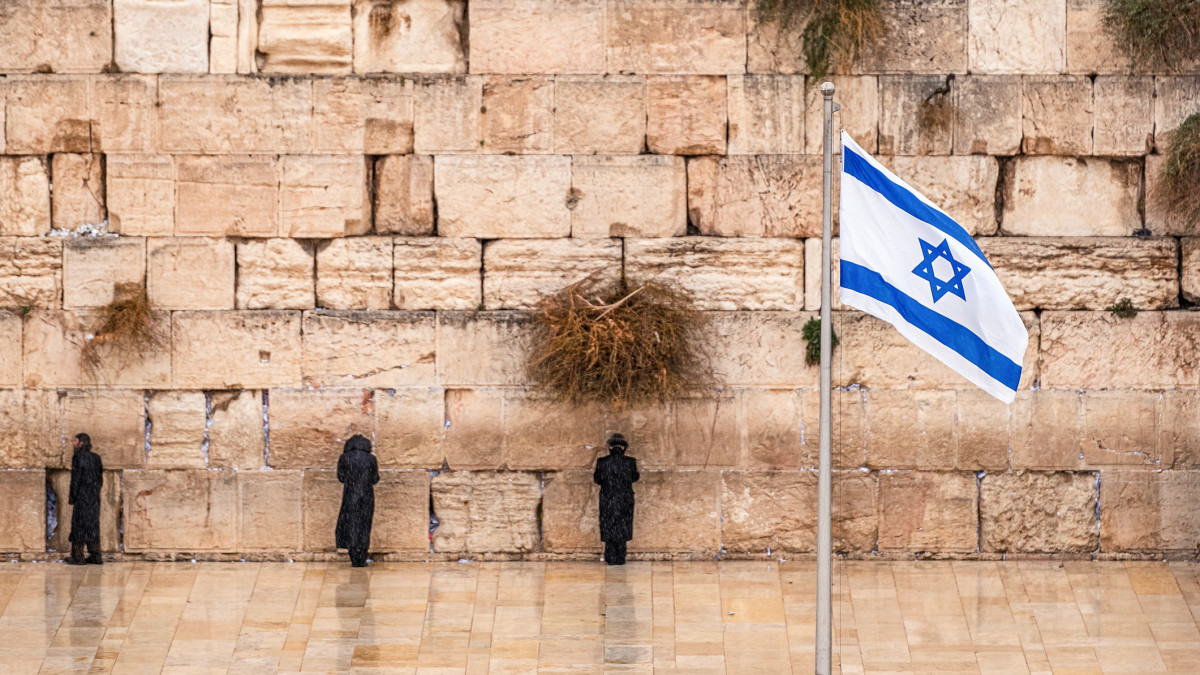 Israeli flag against the western wall  on a cloudy day