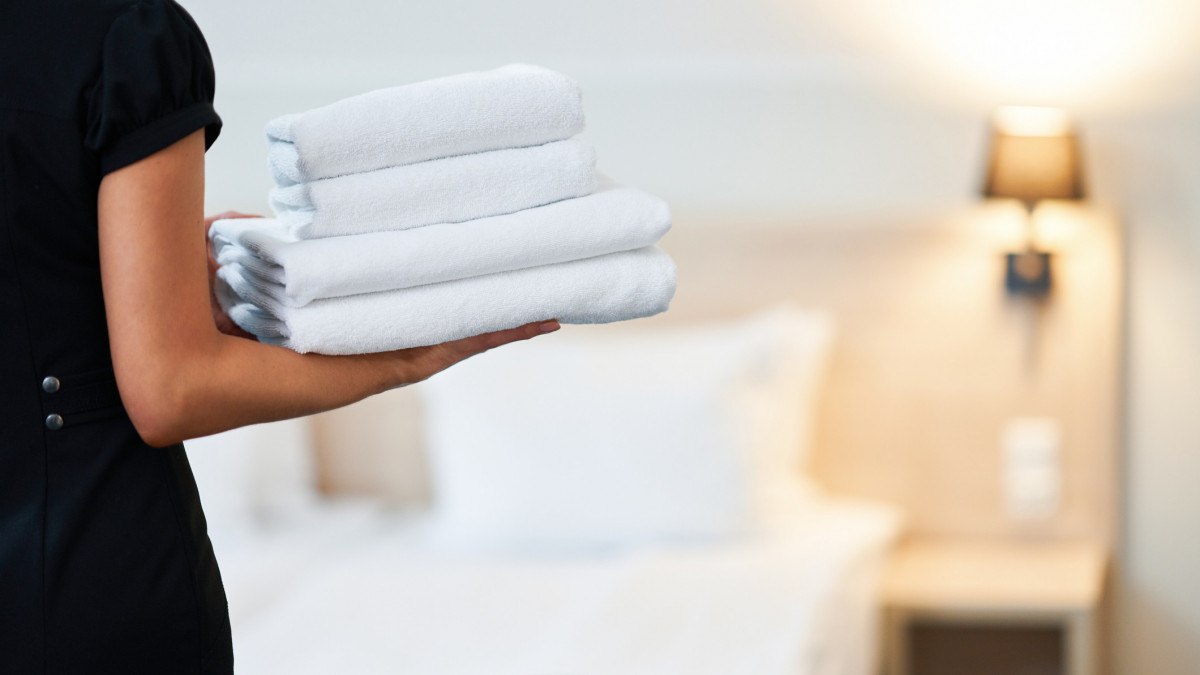 Picture of maid with fresh towels in hotel room