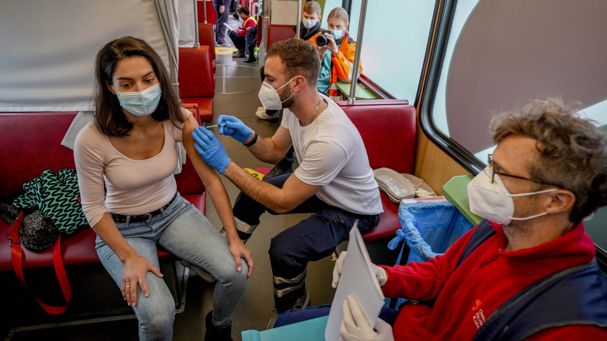 Egy nő megkapja a koronavírus elleni védőoltásának első adagját egy villamoson Frankfurtban 2021. november 4-én. Rekordot döntött az újonnan kiszűrt koronavírus-fertőződések napi száma Németországban, a Robert Koch országos közegészségügyi intézet (RKI) adatai szerint egy nap alatt 33 949 ember szervezetében mutatták ki a koronavírust.