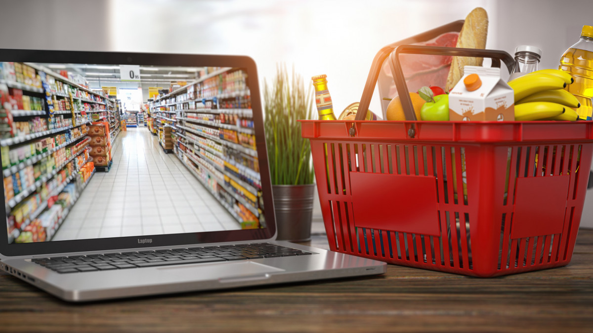 Shopping basket with food and laptop with shelf of supermarket  or grocery shop on the screen. Online ordering and delivery food concept. 3d illustration