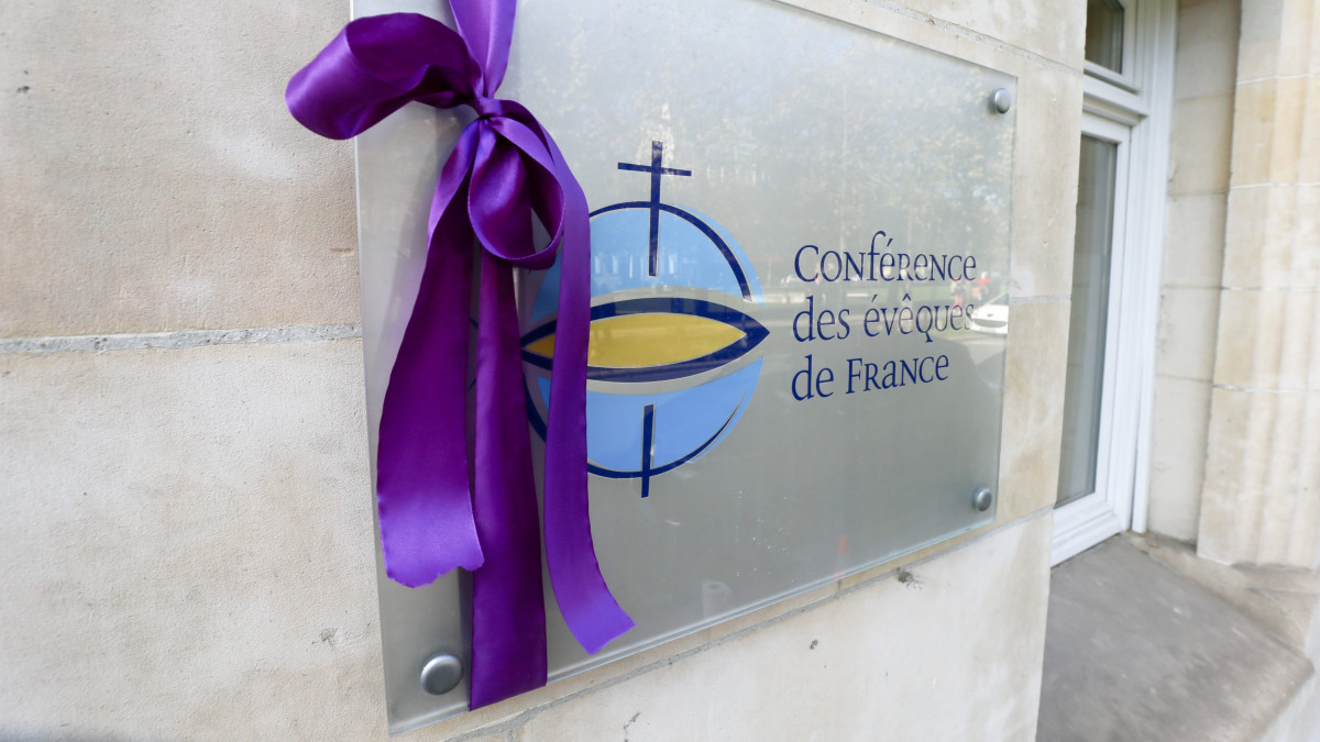 Members of the association De la parole aux actes hang a purple ribbon, the color of the traditional dress of the bishops of the Catholic Church, on the building plate of the headquarters of the Conference des Eveques de France (CEF - French Bishops Conference) in Paris, on November 6, 2021.The annual meeting of bishops began on November 2, 2021 in Lourdes where they have a week to reflect on the follow-up to be given to the revelations of the Sauve report, a month after the publication of a devastating report on widespread child sexual abuse within the institution. (Photo by Michel Stoupak/NurPhoto via Getty Images)