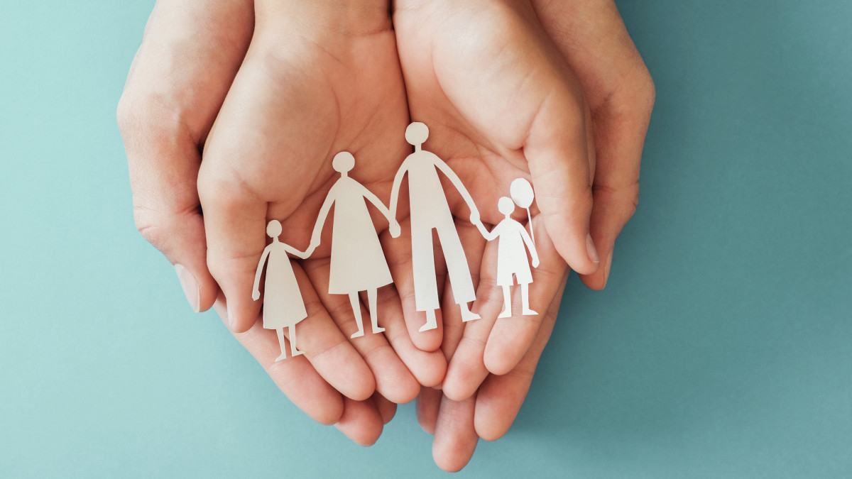 Adult and children hands holding paper family cutout, family home, foster care, homeless charity support concept, family mental health, international day of families