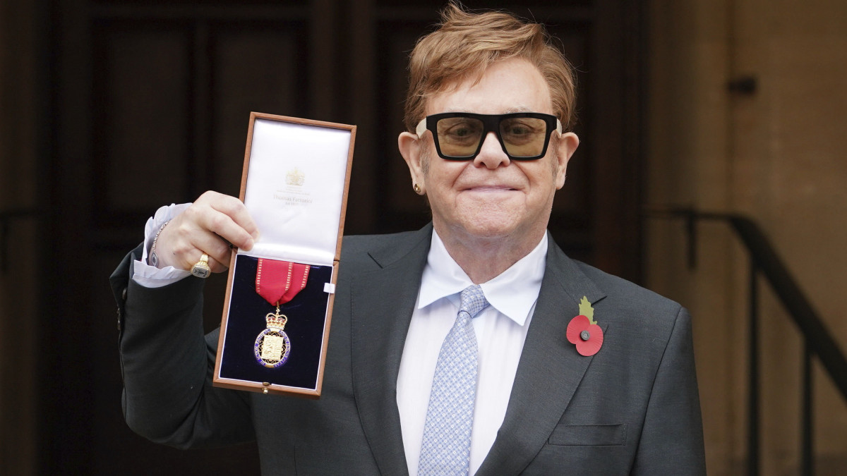 Elton John brit zenész a rendjelet mutatja, miután Károly walesi herceg, brit trónörökös a brit becsületrend tagjává avatta a windsori kastélyban 2021. november 10-én.