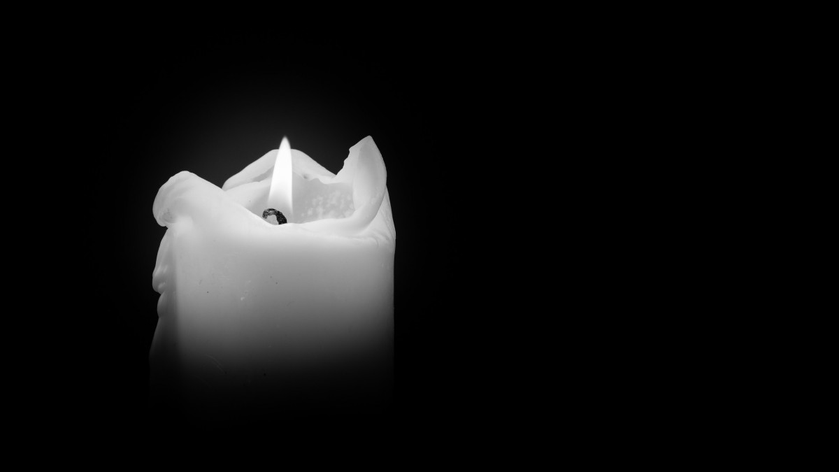 Candles Burning at Night. White Candles Burning in the Dark with focus on single candle in foreground