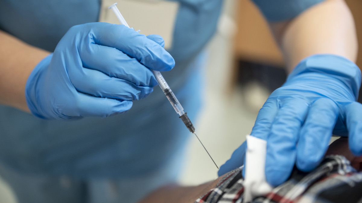 Beoltanak egy férfit a német-amerikai fejlesztésű Pfizer-BioNTech koronavírus elleni oltóanyag, a Comirnaty-vakcina harmadik, emlékeztető adagjával a salgótarjáni Szent Lázár Megyei Kórház oltópontján 2021. november 21-én.