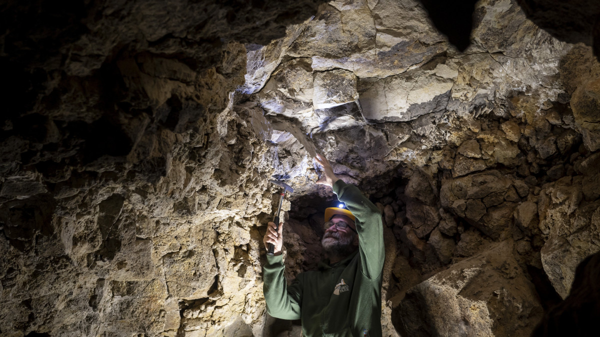 Prakfalvi Péter, a Novohrad-Nógrád Geopark geológusa a Mátraverebély-Szentkúton újonnan felfedezett barlangban 2021. november 24-én. A legalább száz éve felhagyott kőbánya falából nyíló természetes eredetű üreg 9 méter hosszú és 1,5-2,0 méter magas.