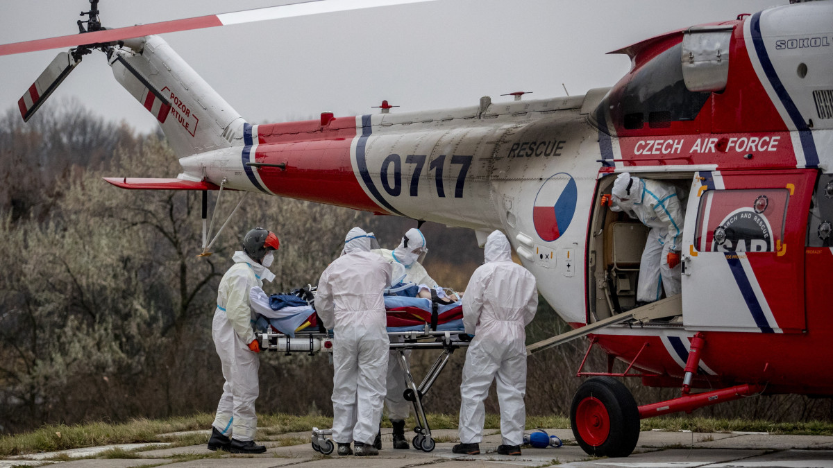 Védőruházatot viselő egészségügyi alkalmazottak egy helikopterrel szállított koronavírussal fertőzött beteget visznek kórházba Prágában 2021. november 25-én, a koronavírus-járvány negyedik hulláma idején. Csehországban egy nap alatt több mint 18 ezer új beteget vettek nyilvántartásba.
