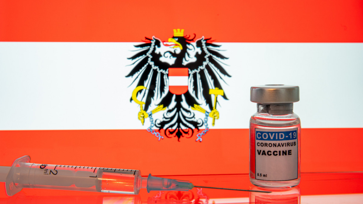 COVID-19 Coronavirus vaccine and syringe with Austrian flag on background. COVID-19 vaccination program begins in Europe