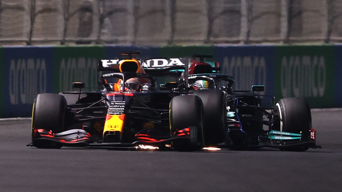 JEDDAH, SAUDI ARABIA - DECEMBER 05: Max Verstappen of the Netherlands driving the (33) Red Bull Racing RB16B Honda and Lewis Hamilton of Great Britain driving the (44) Mercedes AMG Petronas F1 Team Mercedes W12 collide during the F1 Grand Prix of Saudi Arabia at Jeddah Corniche Circuit on December 05, 2021 in Jeddah, Saudi Arabia. (Photo by Lars Baron/Getty Images)