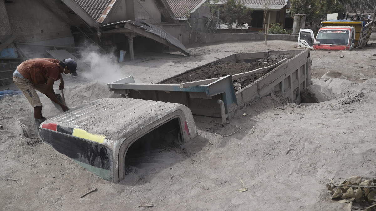 A vulkáni hamuval teljesen beborított teherautóját próbálja kiásni egy férfi az indonéziai Jáva szigetén található Semeru vulkán kitörését követően Lumajang körzetben 2021. december 5-én. A természeti katasztrófa következtében legkevesebb tizenhárom ember életét vesztette, több mint ötvenen megsebesültek.