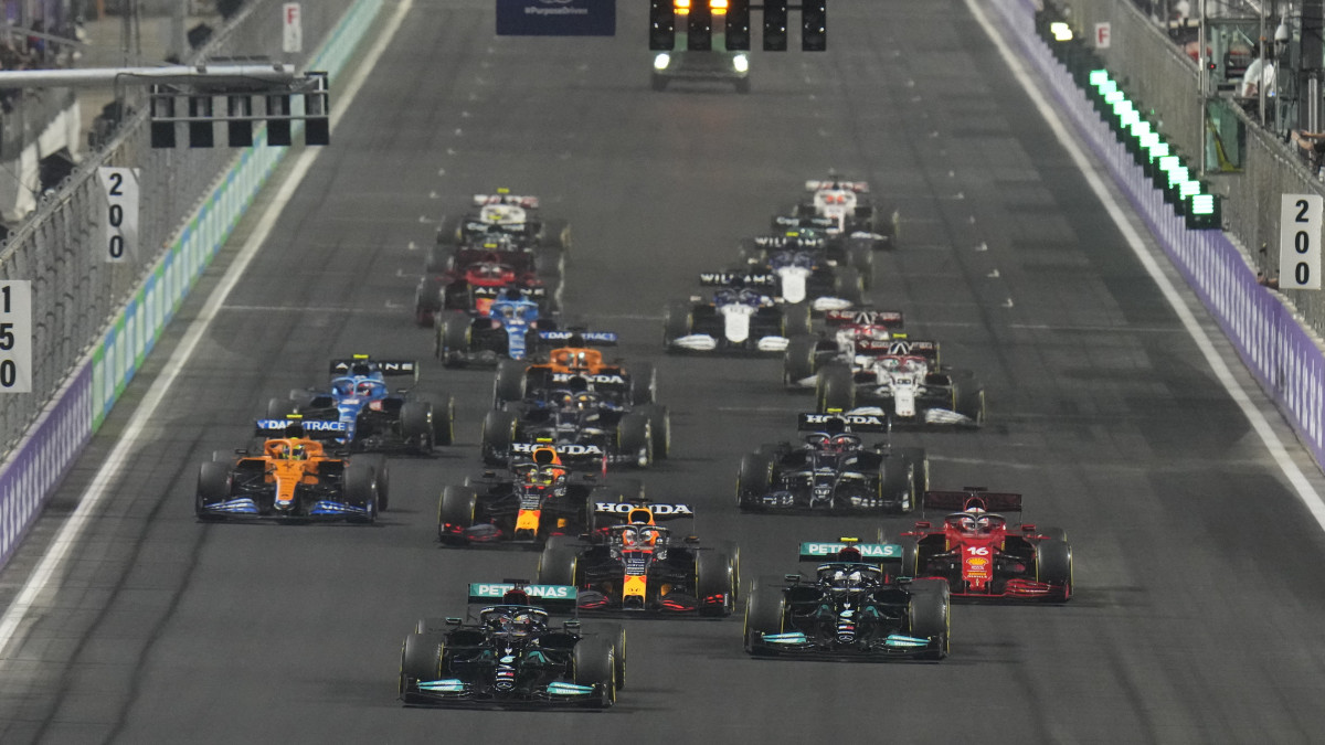 Lewis Hamilton, a Mercedes brit versenyzője (b, elöl) vezeti a mezőnyt a Forma-1-es autós gyorsasági világbajnokság első alkalommal megrendezett Szaúdi Nagydíjának rajtja után a dzsiddai utcai versenypályán 2021. december 5-én.