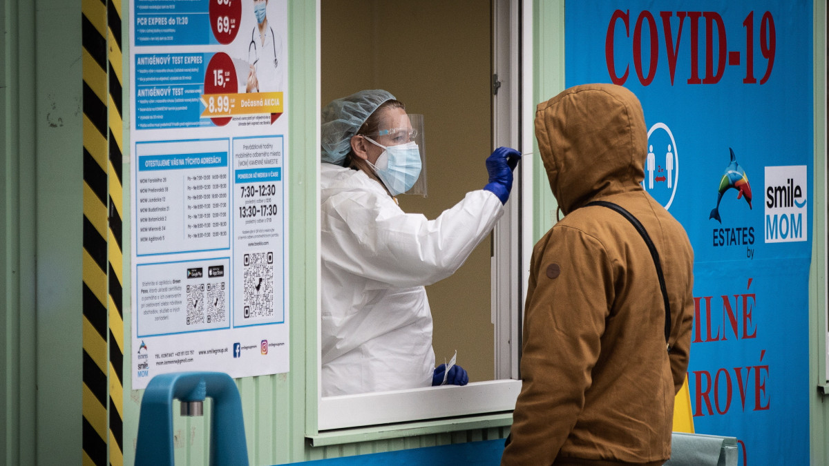 Vizsgálati mintát vesznek koronavírus-tesztre egy férfitől az egyik tesztállomáson Pozsonyban 2021. november 25-én. A szlovák kormány a koronavírus-járvány terjedése miatt három hónapra szükséghelyzetet vezetett be, valamint két hétre kijárási tilalmat rendelt el. Az emberek csak meghatározott indokokkal hagyhatják el otthonaikat, az alapvető fogyasztási cikkek és gyógyszerek beszerzése, a munkahelyre és iskolába, az oltóhelyre, illetve tesztelésre való el utazás céljából.