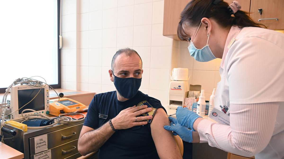 Kiss Róbert rendőr alezredes, a koronavírus-járvány elleni védekezésért felelős operatív törzs ügyeleti központjának munkatársa megkapja a koronavírus elleni oltást a Magyar Honvédség Egészségügyi Központjában 2021. március 8-án.