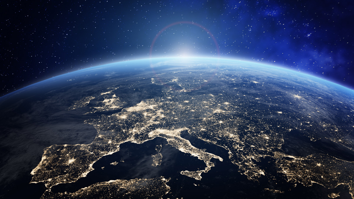 Planet Earth viewed from space with city lights in Europe. World with sunrise. Conceptual image for global business or European communication technology, elements from NASA