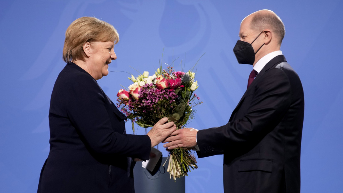 Olaf Scholz új német kancellár (j) virágcsokrot ad át elődjének, Angela Merkelnek a kancellári hivatal átadási ünnepségén Berlinben 2021. december 8-án. Olaf Scholz a második világháború utáni Németország kilencedik - és negyedik szociáldemokrata - kancellárja. Elődje, a 2005-ben hivatalba lépett Angela Merkel négy ciklus után távozik a tisztségből.