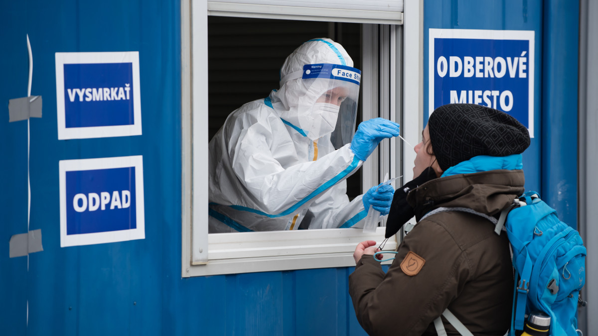 BRATISLAVA, SLOVAKIA - 2021/01/18: A health worker wearing a protective suit takes a nasal swab sample from a woman through a window during the COVID19 mass testing.As the Covid-19 situation in Slovakia remains critical, Slovak government with PM Igor Matovic have introduced mass testing of the population. Starting today 18th of January large-scale testing will continue until 26th of January. The government hopes the nationwide testing will speed up a recovery from the latest wave of the coronavirus. (Photo by Tomas Tkacik/SOPA Images/LightRocket via Getty Images)
