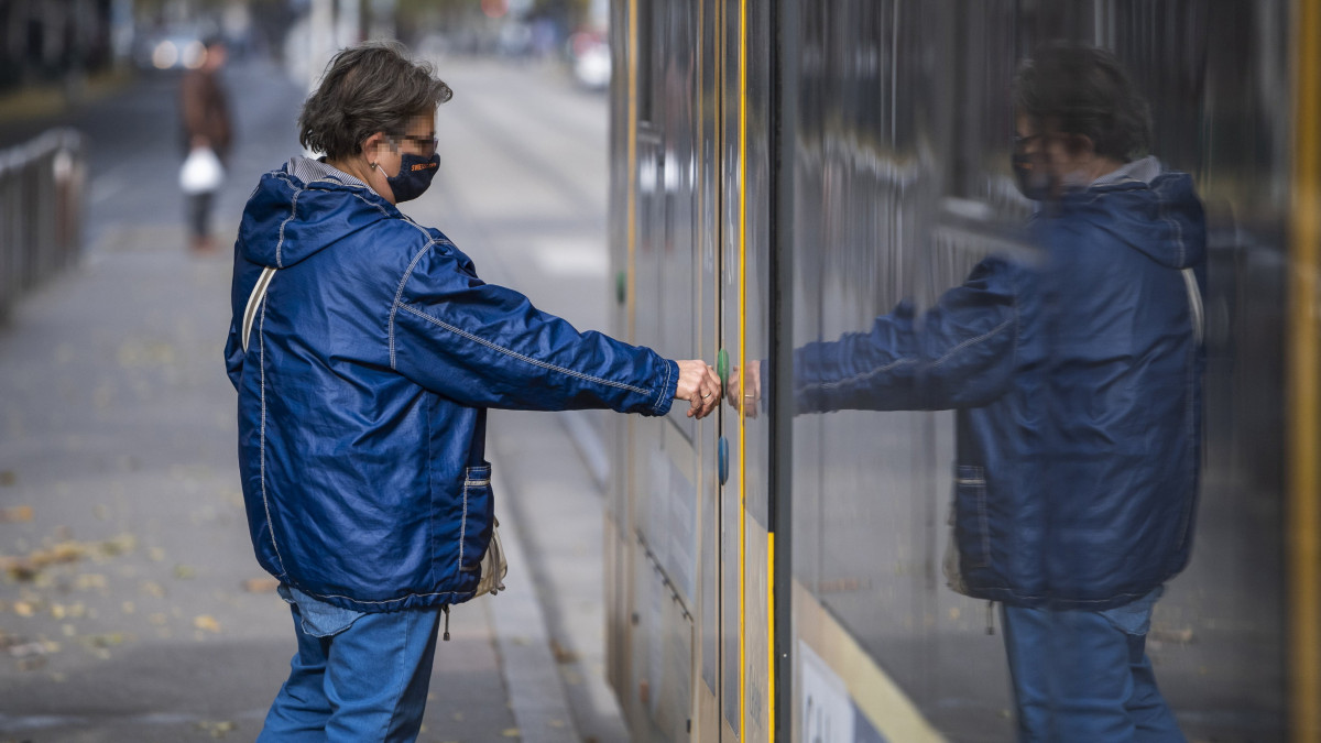 Egészségügyi maszkot viselő utas száll fel egy villamosra Budapesten 2021. november 1-jén. Ettől a naptól a korábban már megszokott szabályok szerint újra maszkot kell viselni a tömegközlekedési eszközökön, pályaudvarokon és megállóhelyeken.