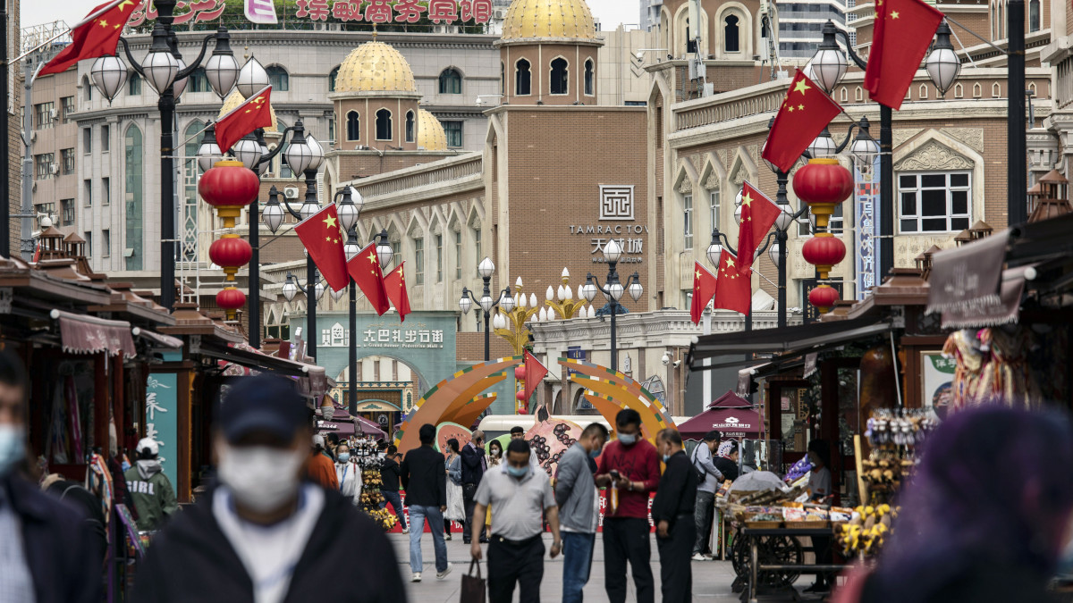 Pedestrians wearing protective masks walk past stalls at the Xinjiang International Grand Bazaar in Urumqi, Xinjiang province, China, on Wednesday, May 12, 2021. China has told nations criticizing its policies inÂ XinjiangÂ to stop interfering in domestic affairs. Source: Bloomberg