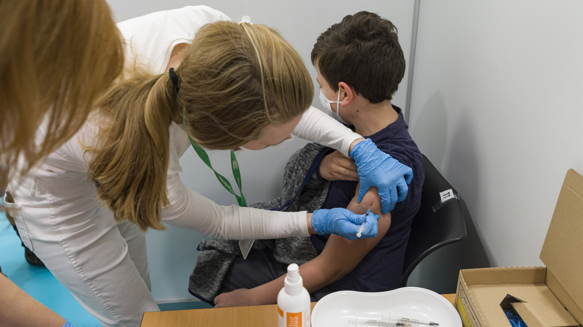 Egy fiút beoltanak a német-amerikai fejlesztésű Pfizer-BioNTech koronavírus elleni oltóanyag, a Comirnaty-vakcina gyerekek oltására alkalmas változatával a győri Petz Aladár Megyei Oktató Kórház oltópontján 2021. december 15-én. Ezen a napon országosan megkezdődött az 5-11 év közötti gyermekek immunizálása, az érintett korosztályból első körben 69 ezren kaphatják meg a vakcinát.