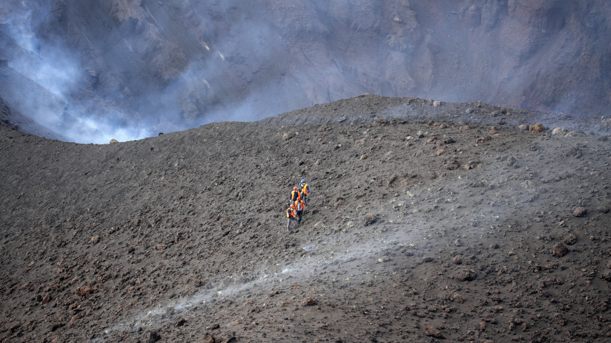 Szakértők a Cumbre Vieja tűzhányó kráterének közelében, a Spanyolországhoz tartozó Kanári-szigetek La Palma szigetén 2021. december 15-én. A vulkán december 13-án este elcsendesedett, és a tudósok szerint az azóta tapasztalható elenyésző tevékenység a szeptember 19-én kezdődő kitörés végének kezdetét jelezheti.