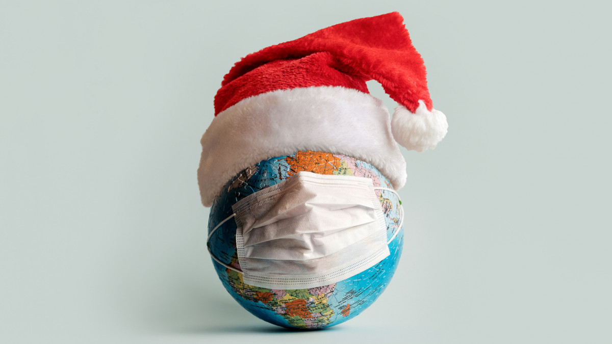 Globe made of jigsaw puzzles with a protective medical mask as a prophylaxis in the fight against coronavirus infection. Measures against the spread of the virus. Marry Christmas and New Year concept