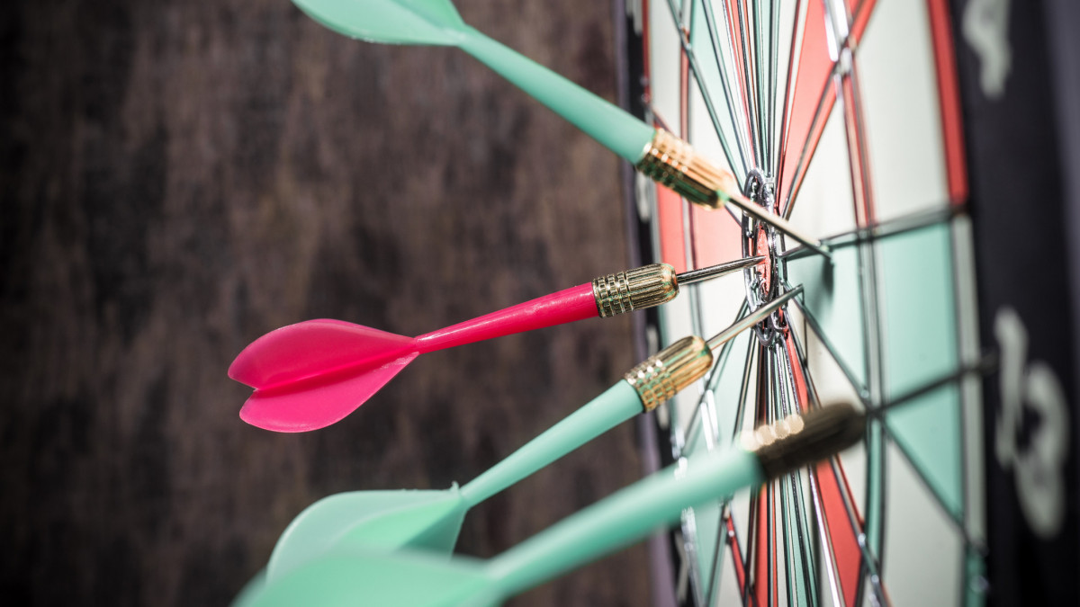 Dart in bulls eye of dartboard with shallow depth of field concept for hitting targetdarts arrows in the target center
