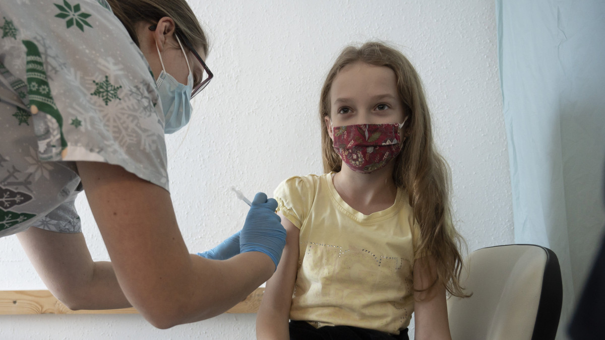 Beoltanak egy lányt a német-amerikai fejlesztésű Pfizer-BioNTech koronavírus elleni oltóanyag, a Comirnaty-vakcina gyerekek oltására alkalmas változatával a hatvani Albert Schweitzer Kórház oltópontján 2021. december 20-án. December 15-én országosan megkezdődött az 5-11 év közötti gyermekek immunizálása, az érintett korosztályból első körben 69 ezren kaphatják meg a vakcinát.