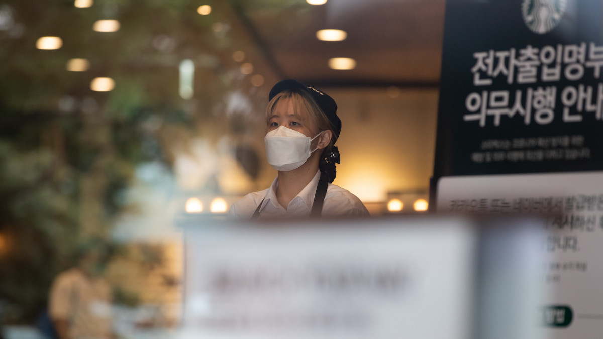 An employee wearing a protective mask stands at the entrance of a Starbucks Corp. store in Seoul, South Korea, on Friday, Sept. 4, 2020. Korea Centers for Disease Control and Prevention Deputy Director Kwon Jun-wook said tighter social distancing rules have clearly helped bring down the pace of new infections, a trend thats likely to continue after the coming weekend. Photographer: SeongJoon Cho/Bloomberg via Getty Images