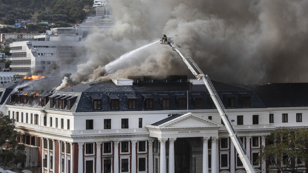 Sűrű füsttel ég a dél-afrikai parlament teteje, ahol ismét felcsaptak a lángok azt követően, hogy a tűzoltóknak a délelőtt folyamán sikerült megfékezni az épület tetőszerkezetében előző nap keletkezett lángokat Fokvárosban 2022. január 3-án. A tűzben leomlott az alsóháznak otthont adó épületszárny teteje, és az 1884-ben épült, a felsőháznak helyt adó régi épületszárny teteje. Gyújtogatás és más bűncselekmények, küztük lopás gyanújával őrizetbe vettek egy 49 éves férfit.