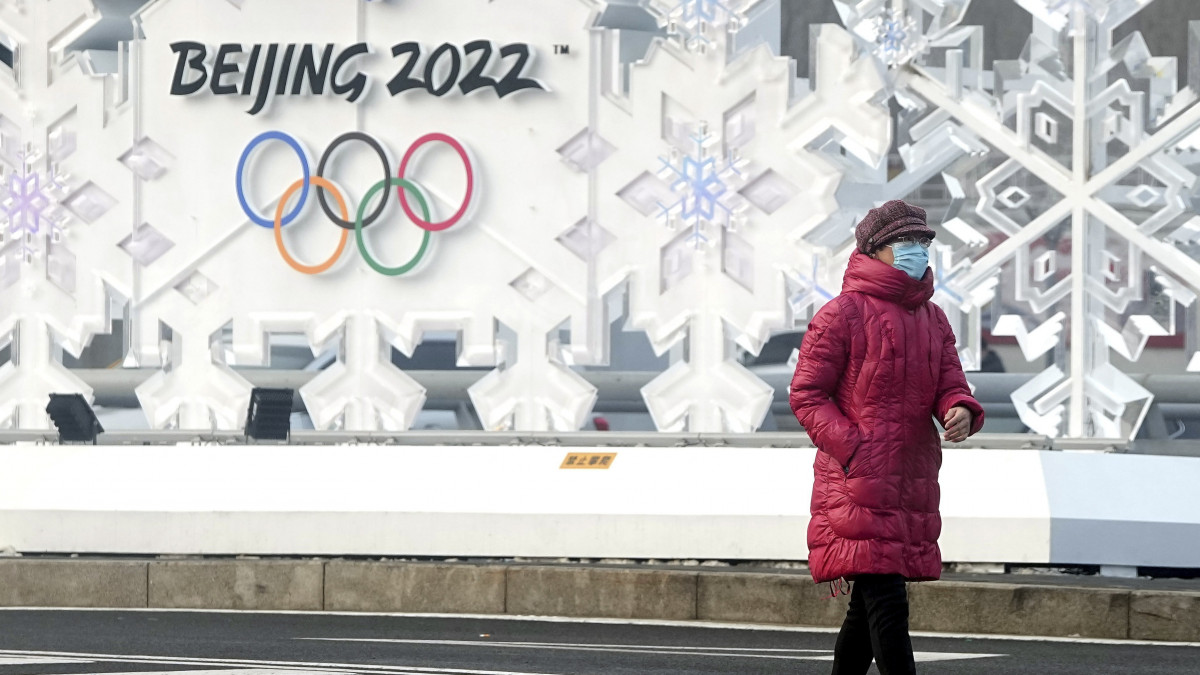Védőmaszkos járókelő a pekingi Olimpiai Park mellett 2022. január 25-én. A kínai fővárosban február 4-20. között rendezik a 2022-es téli ötkarikás játékokat.