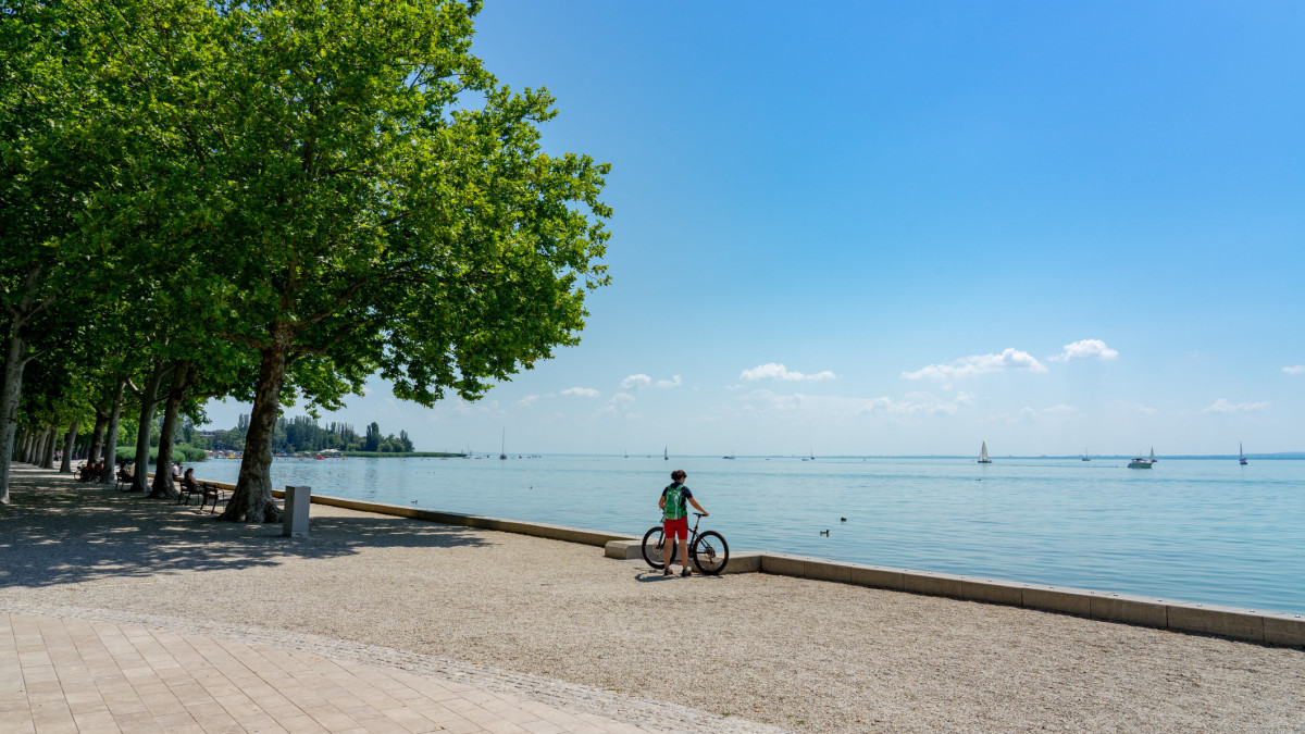 biker with her bicycle next to the Lake Balaton active holiday ride round lake .