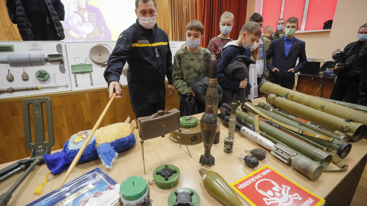 Mentőalakulat egyik tagja különböző típusú aknákat mutat ukrán gyereknek egy kijevi iskolában 2022. január 27-én. Az iskolásoknak megtanítják, hogy mit kell tenniük, ha gyanús tárgyakat vagy lőszert találnak. Nyugati országok az előző hetekben többször is Ukrajna elleni háború előkészítésével vádolták meg Oroszországot, amit Moszkva visszautasított.