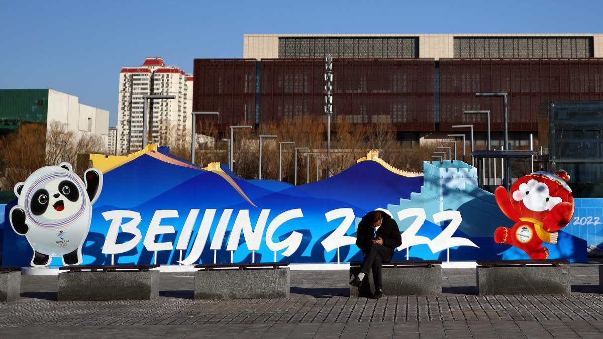 BEIJING, CHINA - JANUARY 27: A person looks at their phone in front of a Beijing 2022 sign in front of the Main Media Center on January 27, 2022 in Beijing, China. The Beijing 2022 Winter Olympics open on February 4, 2022. (Photo by Michael Heiman/Getty Images)