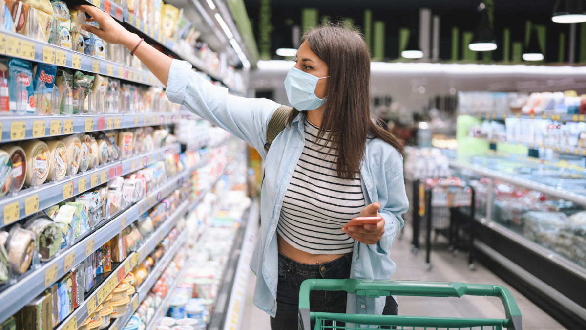 Woman Is shopping at the supermarket while wearing a protective face mask